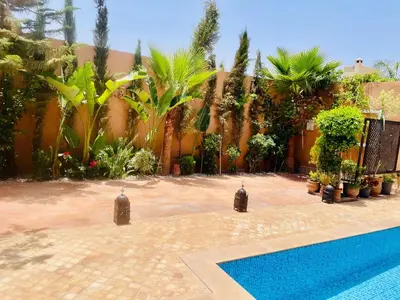 a backyard with a swimming pool and a fence at Villa brek in Marrakech