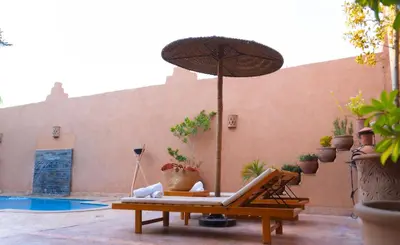 a patio with a chair and an umbrella at Villa brek in Marrakech