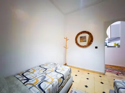 a bedroom with a bed and a cross on the wall at Villa brek in Marrakech