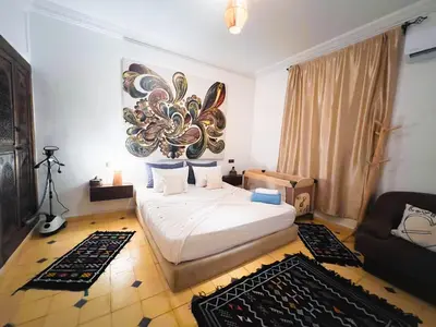 a bedroom with a bed and a picture on the wall at Villa brek in Marrakech