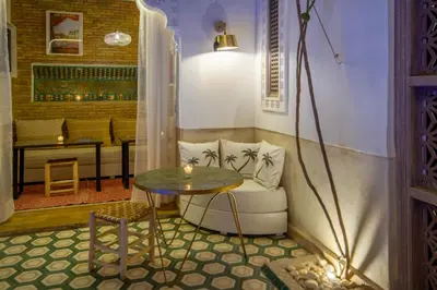 a living room with a table and a couch at Riad Bed & Breakfast Comptoir du Pacha in Marrakech