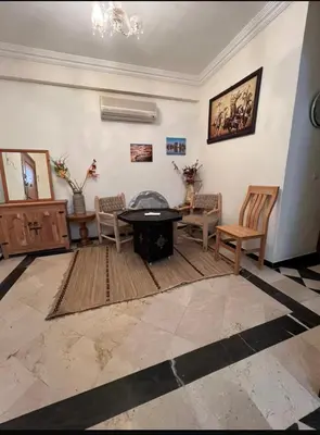 a living room with a table and chairs at Superbe appartement équipé en résidence propre avec Piscine in Marrakech