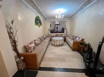 a living room with a couch and a table at Superbe appartement équipé en résidence propre avec Piscine in Marrakech