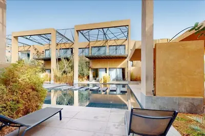 a building with a pool and chairs in front of it at Duplex Moderne 233m2 dans une magnifique résidence in Marrakech