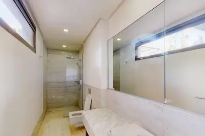 a bathroom with a shower and a toilet and a window at Duplex Moderne 233m2 dans une magnifique résidence in Marrakech