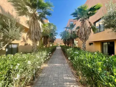 a pathway with palm trees and a building at Duplex Moderne 233m2 dans une magnifique résidence in Marrakech