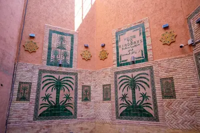 a wall with paintings of palm trees on it at Riad QAYS in Marrakech
