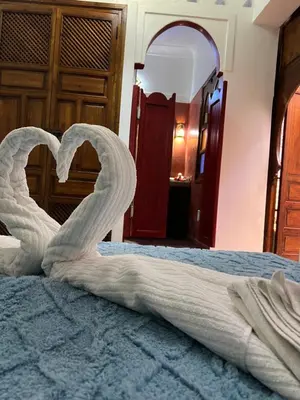 a bed with a white towel forming a heart at Riad La Perla Bianca in Marrakech