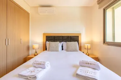a bedroom with a large white bed with towels on it at Résidence golfique, jardin, piscine in Marrakech