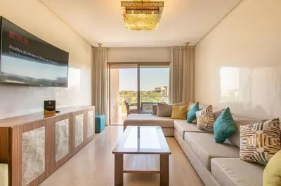 a living room with a couch and a table at Résidence golfique, jardin, piscine in Marrakech