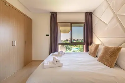a bedroom with a large white bed with towels on it at Résidence golfique, jardin, piscine in Marrakech