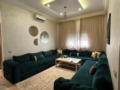 a living room with a green couch and a table at Appartement propre au centre de Marrakech in Marrakech