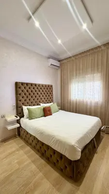 a bedroom with a large bed in a room with a window at Appartement propre au centre de Marrakech in Marrakech