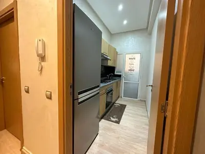 a small kitchen with a stove and a refrigerator at Appartement propre au centre de Marrakech in Marrakech
