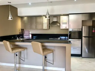a kitchen with a large counter with two stools at studio avec terasse carre eden iptv wifi in Marrakech