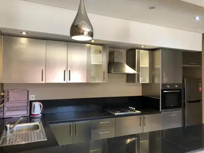 a kitchen with stainless steel cabinets and a black counter top at studio avec terasse carre eden iptv wifi in Marrakech