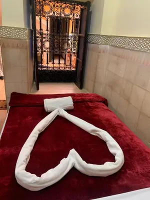 a red bed with two towels on top of it at Riad Douja in Marrakech