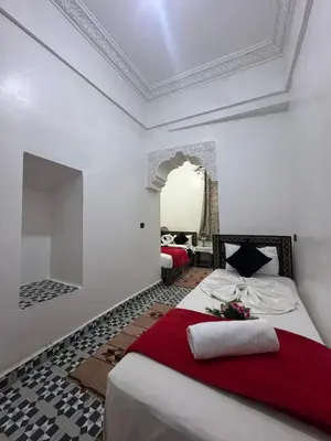 a bedroom with a bed with a red blanket at Riad Douja in Marrakech