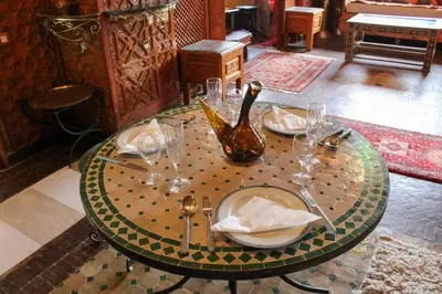 a table with glasses and a vase on top of it at Atypical functional flat Gueliz close Garden Harti in Marrakech