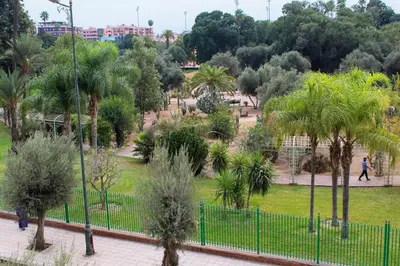 a park with palm trees and a fence at Atypical functional flat Gueliz close Garden Harti in Marrakech