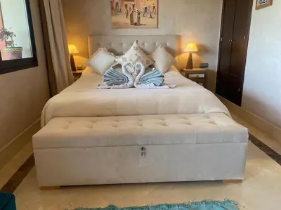 a large white bed with a large white ottoman at Superbe pied à terre sur Majorelle in Marrakech