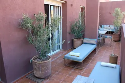 a patio with potted plants and a blue bench at SUBLIME APPARTEMENT 2 CHAMBRES AU COEUR DE GUELIZ in Marrakech