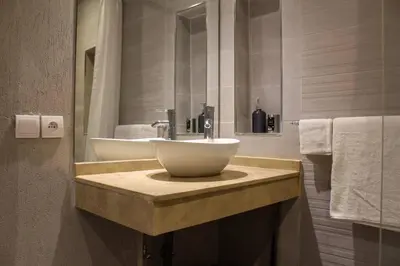 a bathroom with a white sink and a mirror at SUBLIME APPARTEMENT 2 CHAMBRES AU COEUR DE GUELIZ in Marrakech