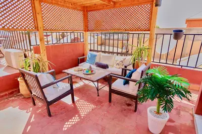 a patio with a couch and a table on a balcony at full home pool terrasse résidence alqaria assiyahiya in Marrakech