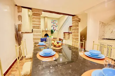 a dining room with a table with blue dishes on it at full home pool terrasse résidence alqaria assiyahiya in Marrakech