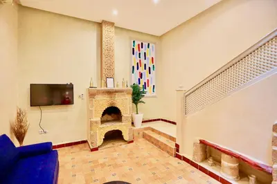 a living room with a fireplace and a tv at full home pool terrasse résidence alqaria assiyahiya in Marrakech