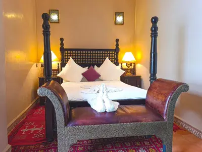 a bedroom with a bed with two shoes on a bench at Riad Jaime in Marrakech