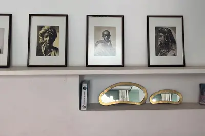 a shelf with framed pictures and a mirror on it at Riad Nadara, superbe riad au coeur de la medina! in Marrakech