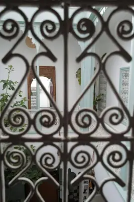 a view of a door through a wrought iron gate at Riad Nadara, superbe riad au coeur de la medina! in Marrakech