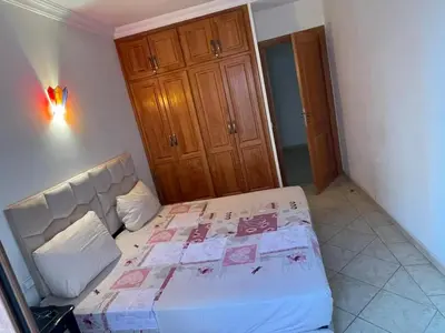 a bedroom with a bed in a room with a cabinet at Superbe appartement à Marrakech quartier Majorelle 2 chambres in Marrakech
