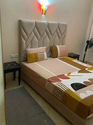 a bedroom with a bed with a headboard and a table at Superbe appartement à Marrakech quartier Majorelle 2 chambres in Marrakech