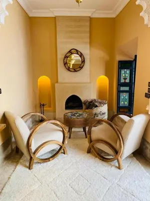 a living room with two chairs and a fireplace at Riad Casa nomad in Marrakech