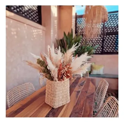 a vase filled with feathers sitting on a wooden table at Riad Casa nomad in Marrakech