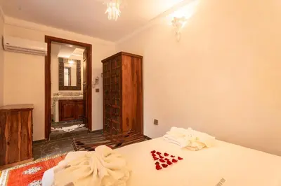 a room with a bed and a dresser and a mirror at Palais Aix Kabaj &Spa in Marrakech