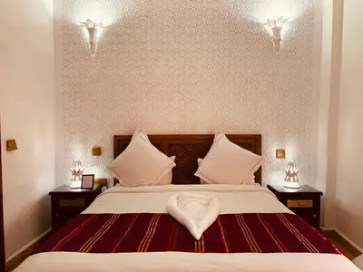 a bedroom with a bed with a heart shaped pillow on it at Palais Aix Kabaj &Spa in Marrakech