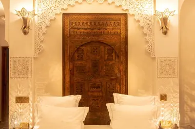 a room with a wooden door and two beds at Palais Aix Kabaj &Spa in Marrakech