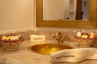 a sink in a bathroom with a mirror and towels at Palais Aix Kabaj &Spa in Marrakech