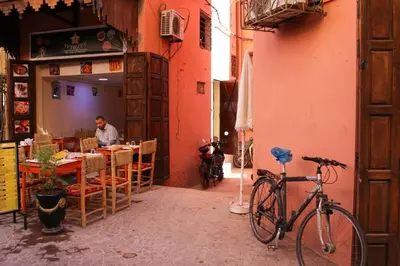 a bike parked next to a restaurant with a man sitting at a table at Atypique appart proche J. El fna in Marrakech