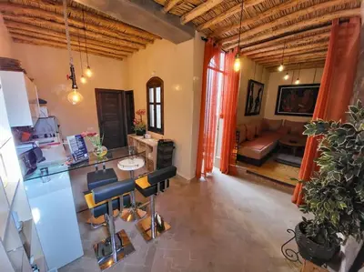 a kitchen and living room with a table and chairs at Atypique appart proche J. El fna in Marrakech