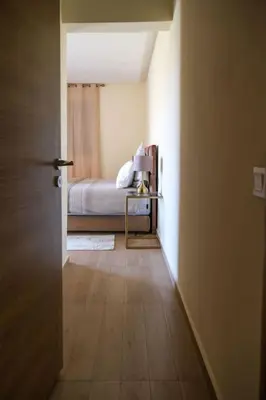 a small room with a bed and a table with a door at Magnifique appart vue piscine in Marrakech