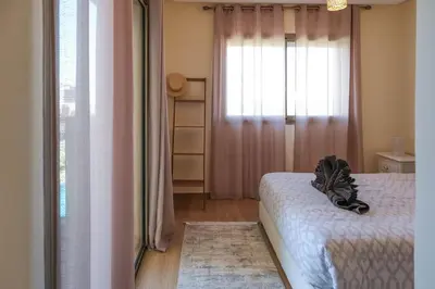 a bedroom with a bed and a window at Magnifique appart vue piscine in Marrakech