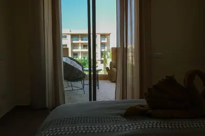 a bedroom with a bed and a view of a balcony at Magnifique appart vue piscine in Marrakech