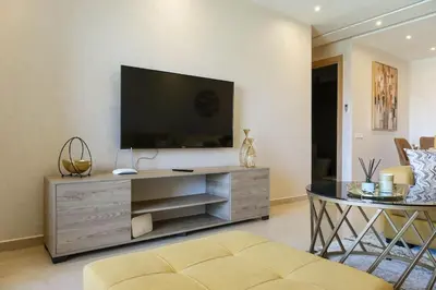 a living room with a entertainment center with a flat screen tv at Magnifique appart vue piscine in Marrakech