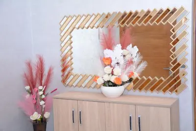 a mirror and a vase of flowers on a cabinet at apartment Marrakech, gueliz in Marrakech