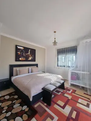 a bedroom with a large bed and a rug at La Perle de Marrakech by Atlas Golf Resort in Marrakech