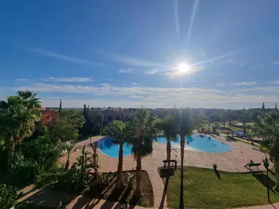 a view of the pool from the balcony of a resort at La Perle de Marrakech by Atlas Golf Resort in Marrakech